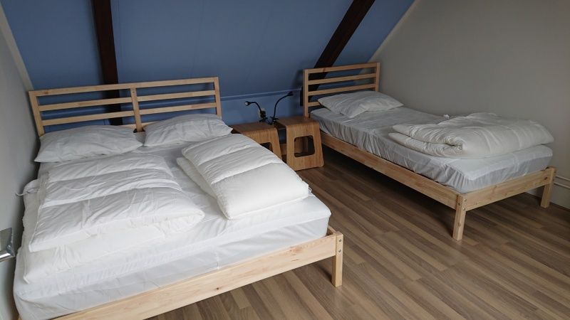 Gemuetliches Schlafzimmer im Ferienhaus Kikkerpoel, De Cocksdorp, Texel mit zwei Einzelbetten und Holzboden.