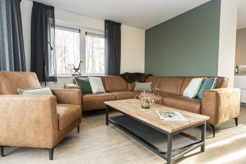 Stijlvolle woonkamer in Duinoord Texel vakantiehuis, De Cocksdorp, met comfortabele leren banken.