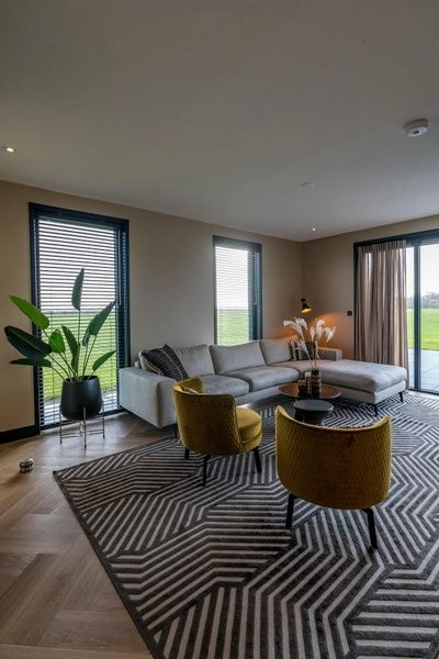 Lichte woonkamer van 6 persoons vakantiewoning in De Cocksdorp, Texel met stijlvolle inrichting en uitzicht op de natuur.