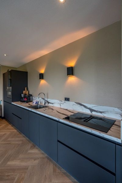 Moderne keuken in 6 persoons vakantiewoning, De Cocksdorp, Texel met marmeren aanrecht en sfeervolle verlichting.