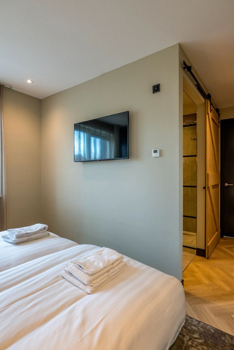 Slaapkamer met televisie in 6 persoons vakantiewoning, De Cocksdorp, Texel met moderne badkamer toegang.