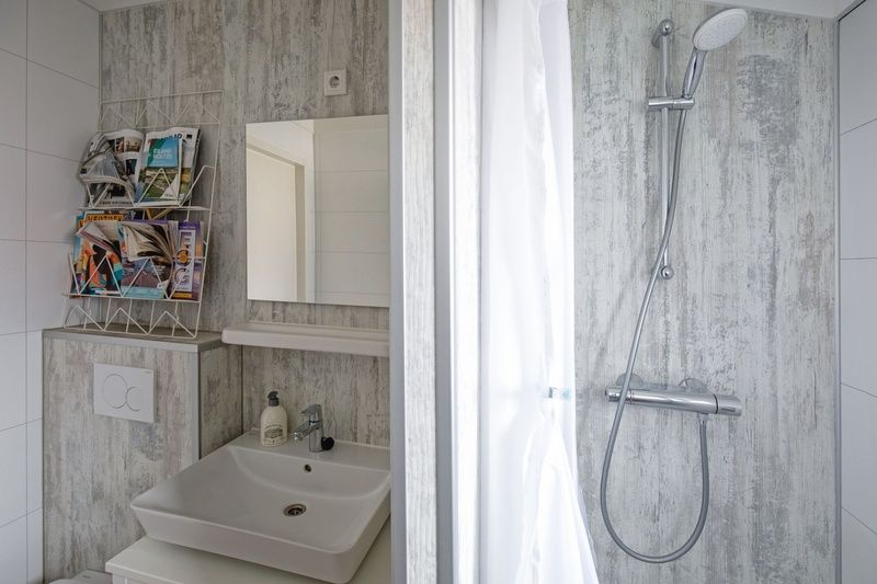 Moderne badkamer van Chalet Bregkoog 52, De Koog, Texel, met douche en wastafel bij Chaletpark Bregkoog.