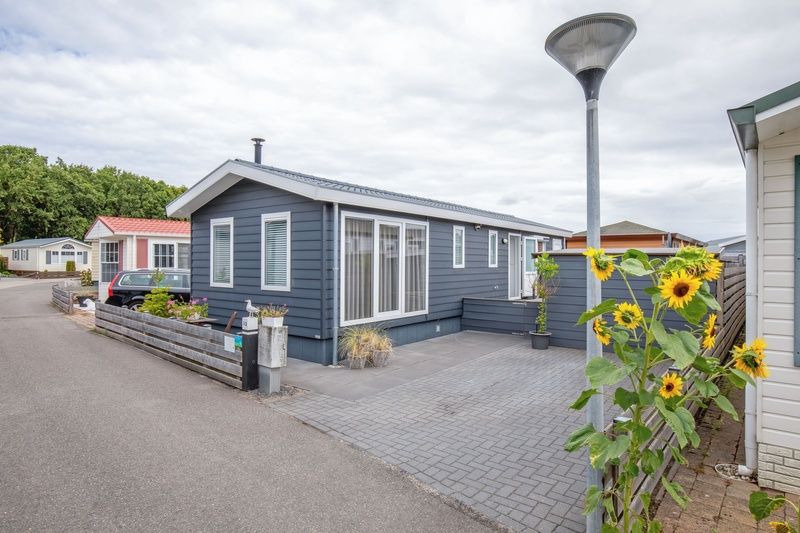 Vooraanzicht van Chalet Bregkoog 52, De Koog, Texel, met strak terras bij Chaletpark Bregkoog.