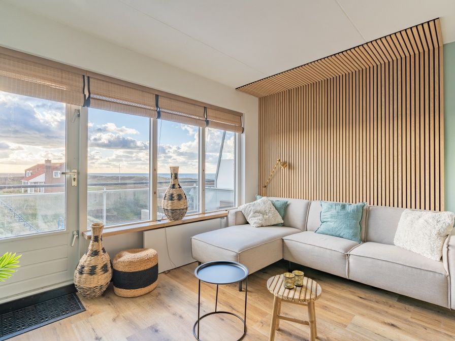 Appartement Juliana 140 Eiland en Zeezicht in De Koog, Texel biedt een sfeervolle woonkamer met uitzicht op de duinen.