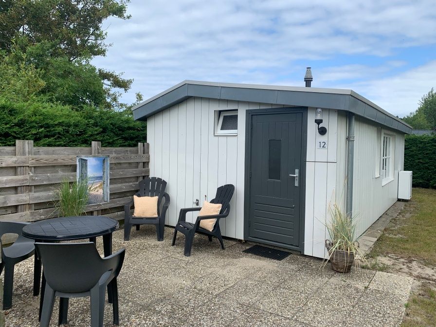 Geniet van het terras bij vakantiehuis Hoog Koog 12 in Bungalowpark Hoog Koog, De Koog, Texel, omringd door groene natuur.