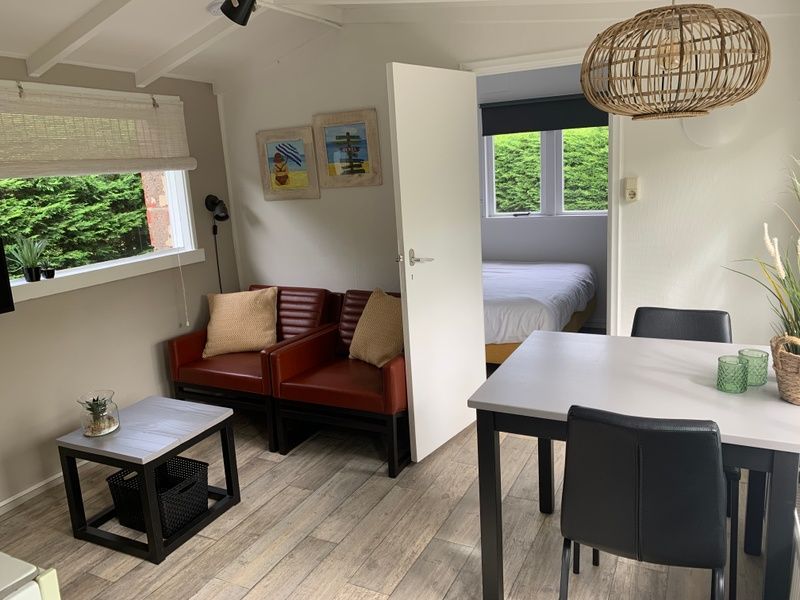 Gezellige woonkamer van vakantiehuis Hoog Koog 12 in Bungalowpark Hoog Koog, De Koog, Texel, met comfortabele zithoek en eethoek.