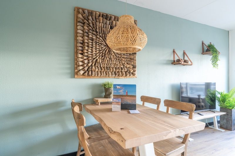 Eettafel en decoratieve kunst in Appartement Juliana 140 Eiland en Zeezicht, De Koog, Texel voor een gezellige sfeer.