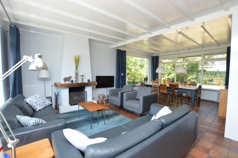 Gezellige woonkamer van Orchismient 45 groot, vakantiehuis in De Koog, Texel, met open haard en comfortabele zithoek.