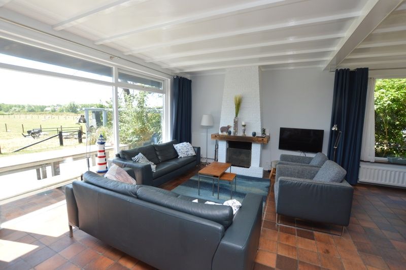 Lichte woonkamer met uitzicht op de natuur bij Orchismient 45 groot, vakantiehuis in De Koog, Texel.