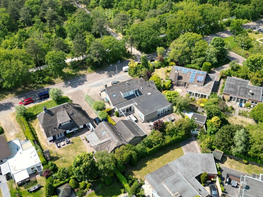 Luchtfoto van Tesselhuus met zorgvleugel in De Koog, Texel, omgeven door groene natuur en nabijgelegen huizen.