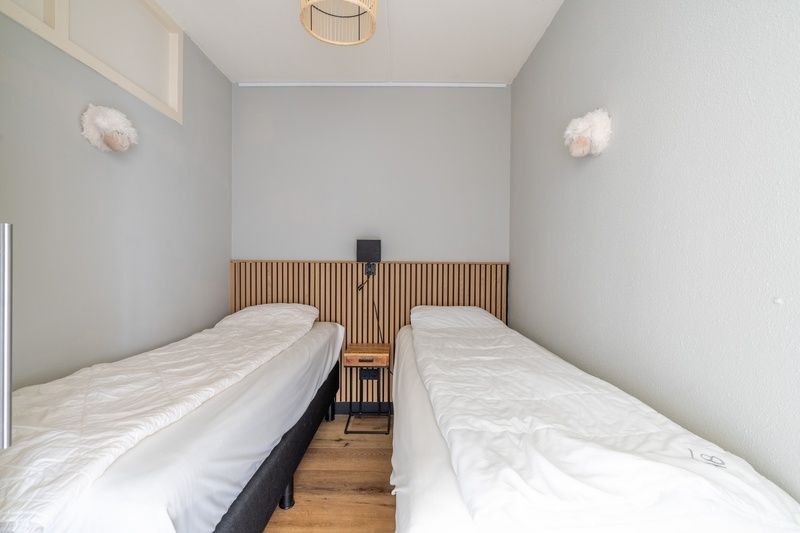 Sfeervolle slaapkamer met twee eenpersoonsbedden in Appartement Juliana 086 Eiland en Zeezicht, De Koog.