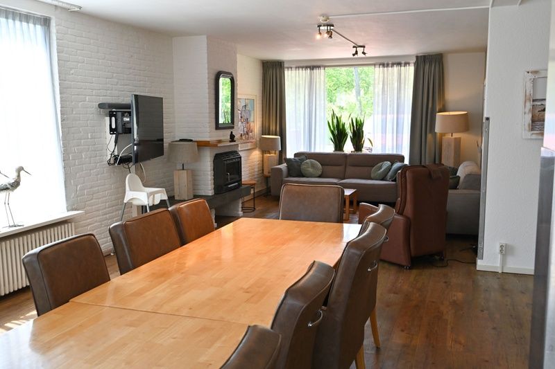 Gezellige woonkamer van Tesselhuus met zorgvleugel, vakantiehuis in De Koog, Texel, met grote eettafel en zithoek.