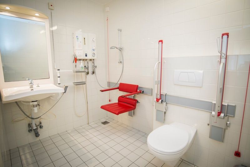 Toegankelijke badkamer in Tesselhuus met zorgvleugel, vakantiehuis in De Koog, Texel, met hulpmiddelen en douche.