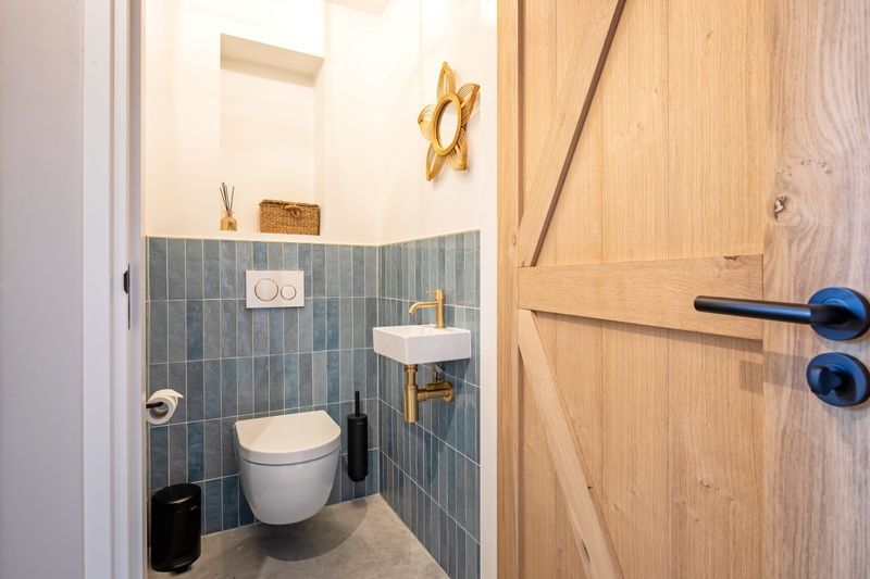 Stijlvolle badkamer met houten deur in Villa Flo, De Koog, Texel.