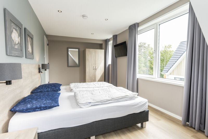 Slaapkamer met uitzicht op de tuin in Villa 17, De Koog, Texel, vakantiehuis op de Waddeneilanden.