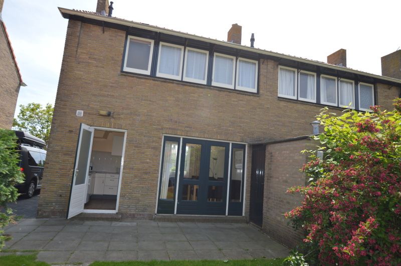 Achtertuin van vakantiehuis Watersnip in De Koog, Texel met terras en groen.