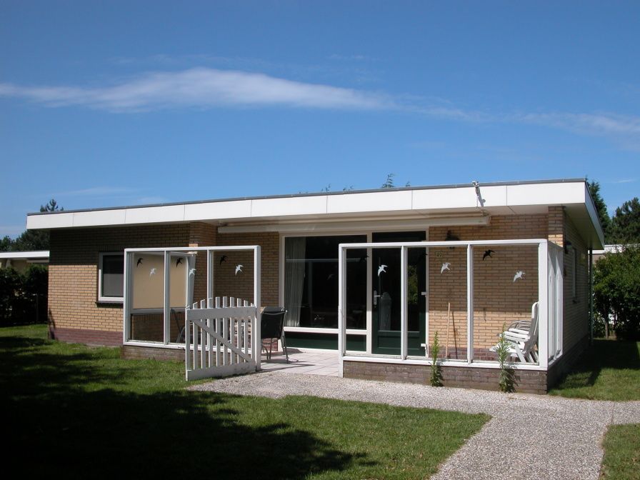 Bungalow 't Luwe Land 49 in De Koog Texel biedt een zonnig terras met groene tuin, ideaal voor ontspanning op de Waddeneilanden.