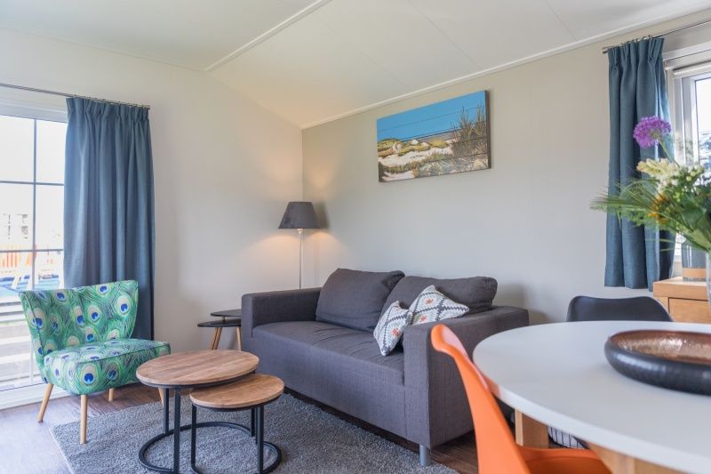 Gemuetliches Wohnzimmer des Chalets Bregkoog 227 in De Koog, Texel, mit bequemen Sitzgelegenheiten und moderner Einrichtung.