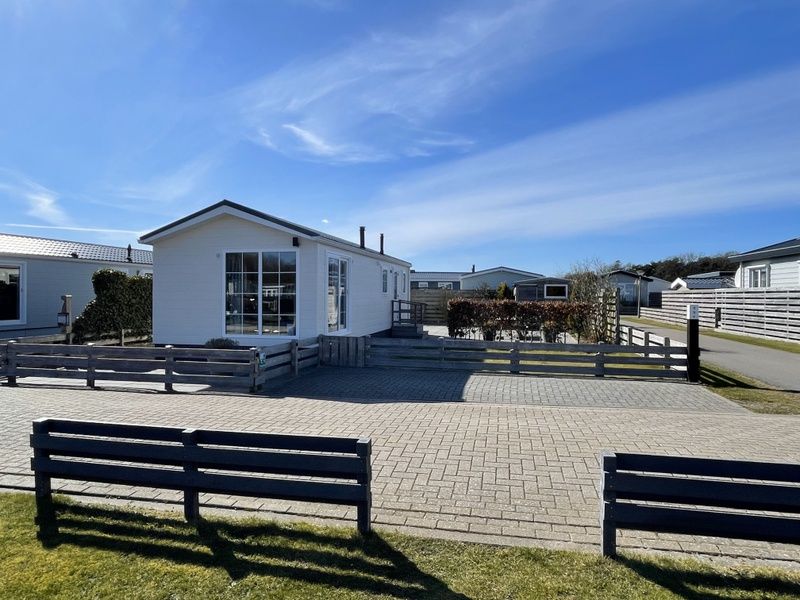 Vorderseite von Chalet Bregkoog 227, Ferienunterkunft in De Koog, Texel mit Sonnenterrasse und grossem Parkplatz.