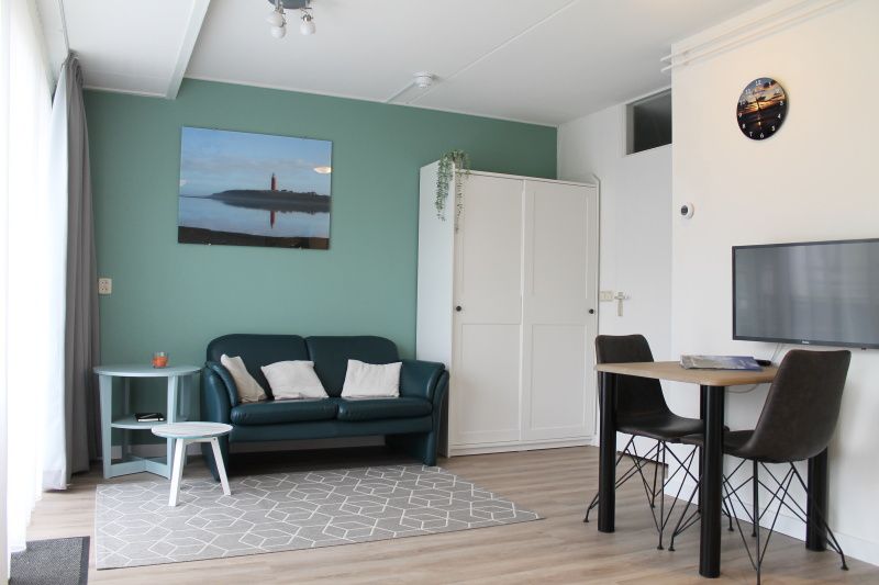 Gezellige woonkamer in De Zeedistel - Appartement Zeedistel 16, een vakantieverblijf in De Koog, Texel, met comfortabele zithoek.