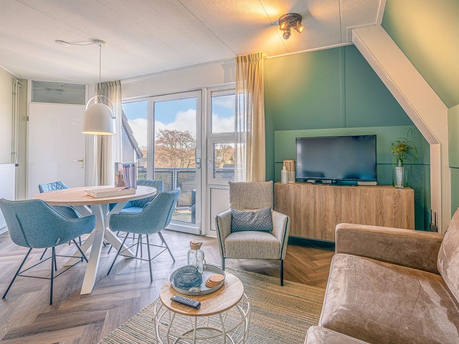 Gezellige woonkamer in Appartement Zeedistel 22, De Koog, Texel met comfortabel meubilair en uitzicht op de Waddeneilanden.