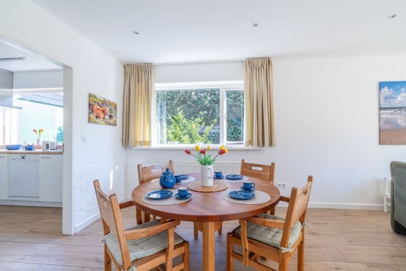 Dining area in Orchismient 14 vacation home, De Koog Texel overlooking the garden.
