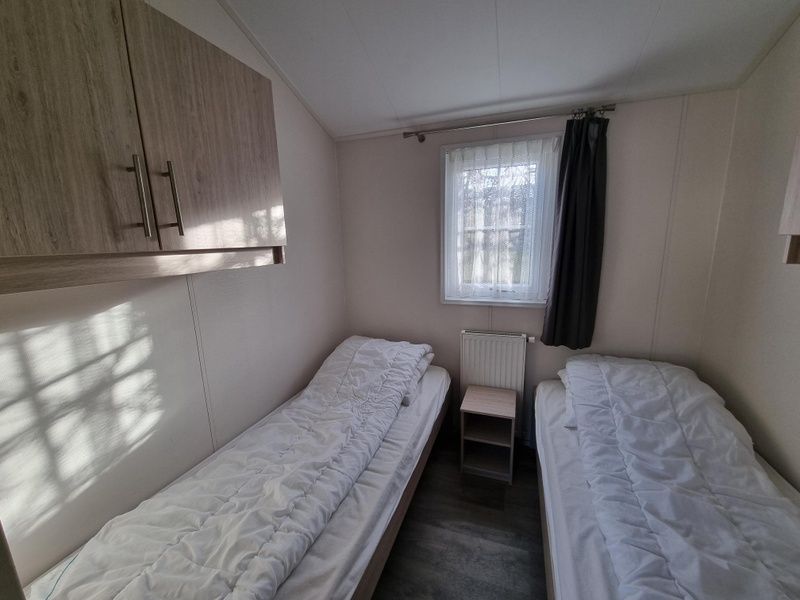 Tweede slaapkamer in Chaletpark Bregkoog - Chalet Bregkoog 235, De Koog, Texel met eenpersoonsbedden en natuurlijk licht.