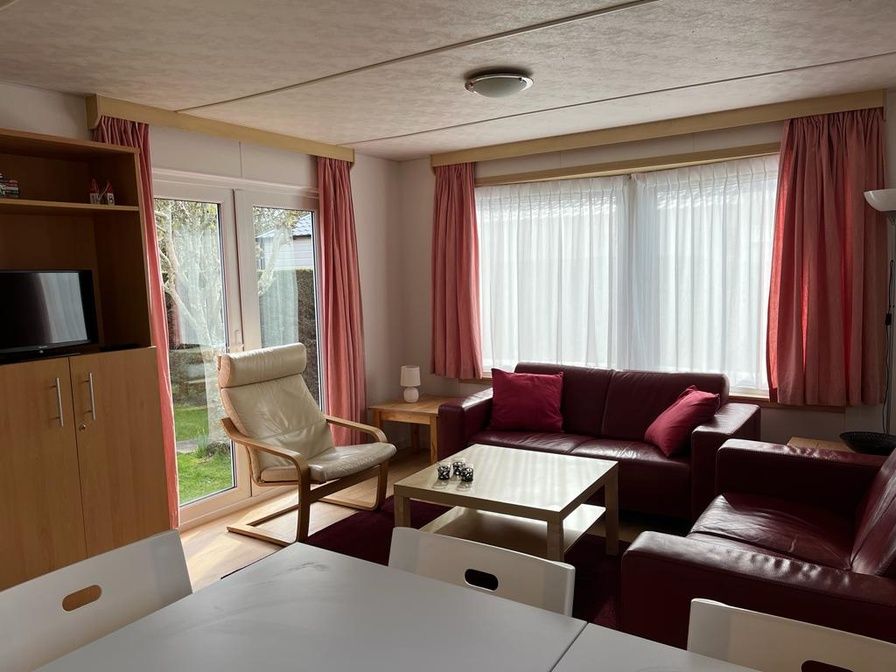 Gemuetliches Wohnzimmer des Chalets Jori auf dem Campingplatz Coogherveld in De Koog, Texel. Gemuetliche Sitzecke mit viel natuerlichem Licht.