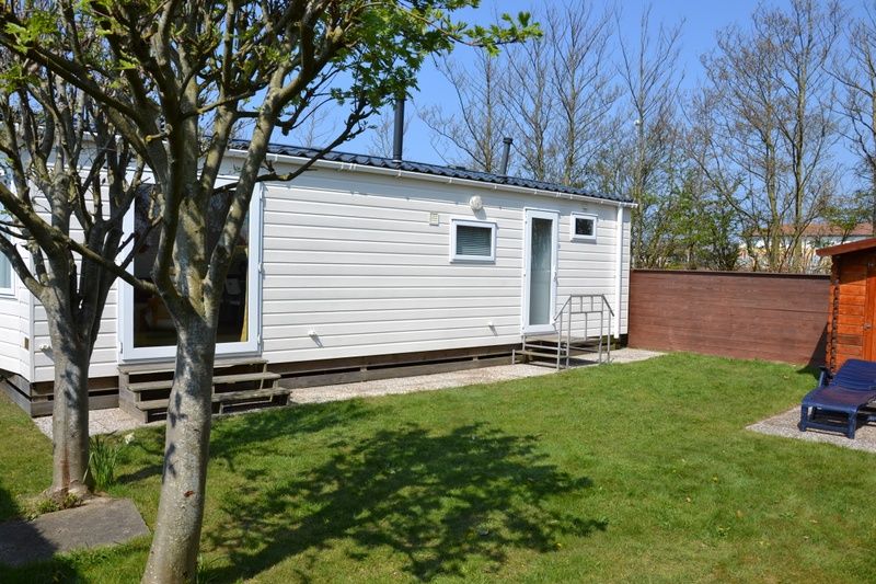 Camping Coogherveld - Chalet Jori in De Koog, Texel, bietet einen ruhigen Aussenbereich mit gruenem Garten und schoener Terrasse.