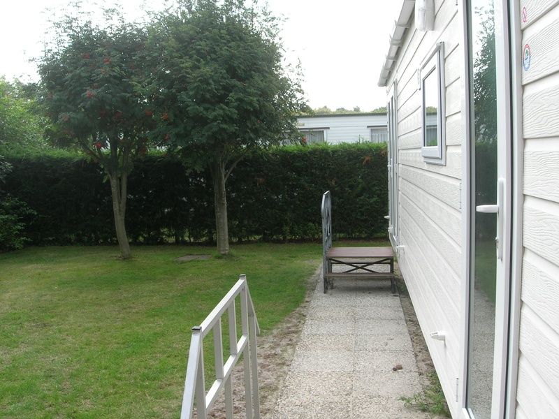 Geniessen Sie den ruhigen Garten auf Camping Coogherveld - Chalet Jori in De Koog, Texel. Entspannen Sie sich in der natuerlichen Umgebung dieses Ferienhauses.