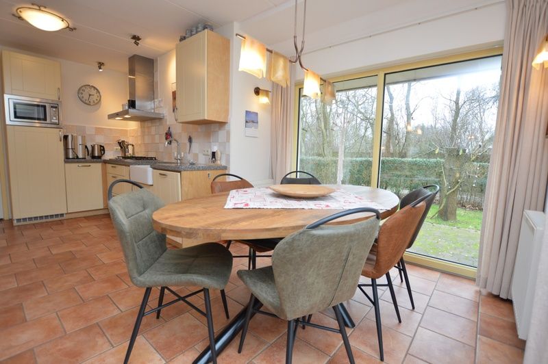 Eethoek met uitzicht op de tuin in Vakantiehuis 7K, De Koog, Texel, ideaal voor familiediners.