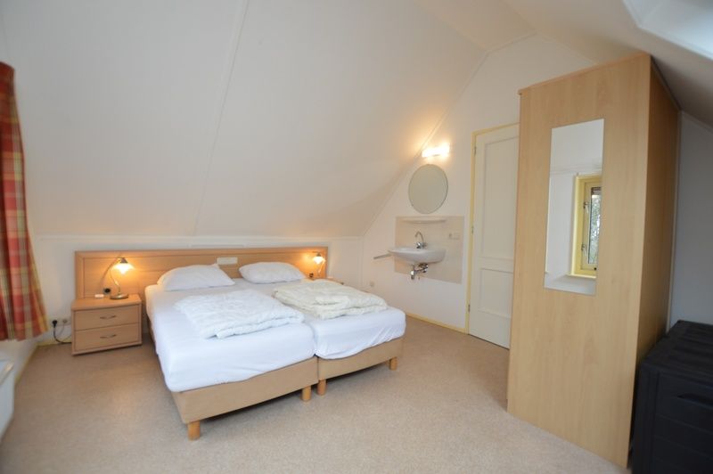 Lichte slaapkamer op bovenverdieping van Vakantiehuis 7K, De Koog, Texel met comfortabele bedden.