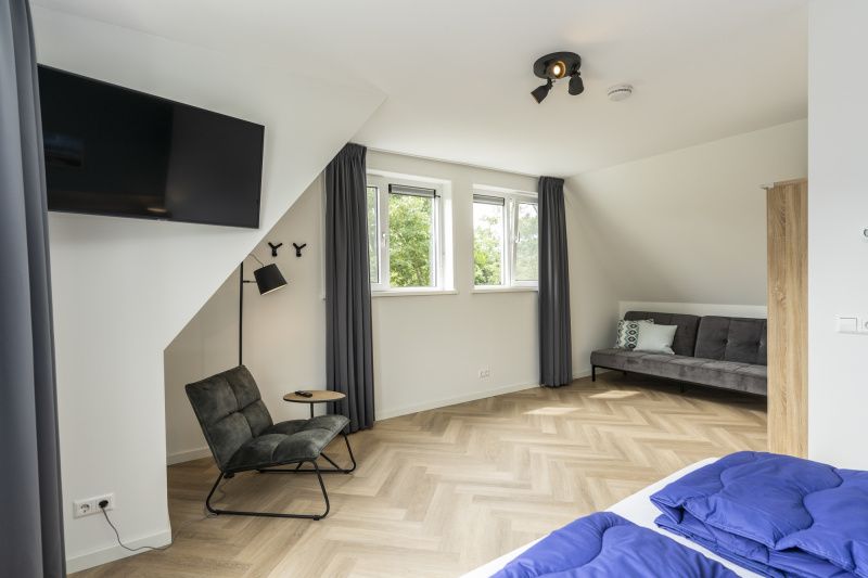 Seating area in Villa 39 De Koog Texel with modern decor and views of greenery.