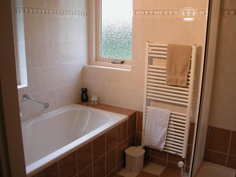 Ontspan in de moderne badkamer van Bungalow 25, De Koog Texel, met ligbad op de Waddeneilanden.