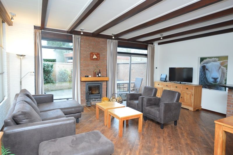 Gezellige woonkamer in Orchismient 28 vakantiehuis De Koog Texel met open haard.