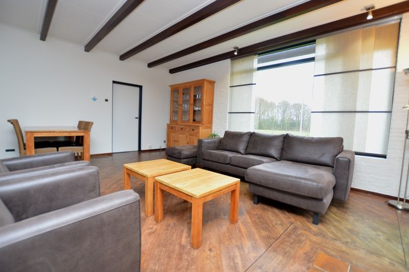 Stijlvolle woonkamer van Orchismient 28 vakantiehuis Texel met houten meubels.