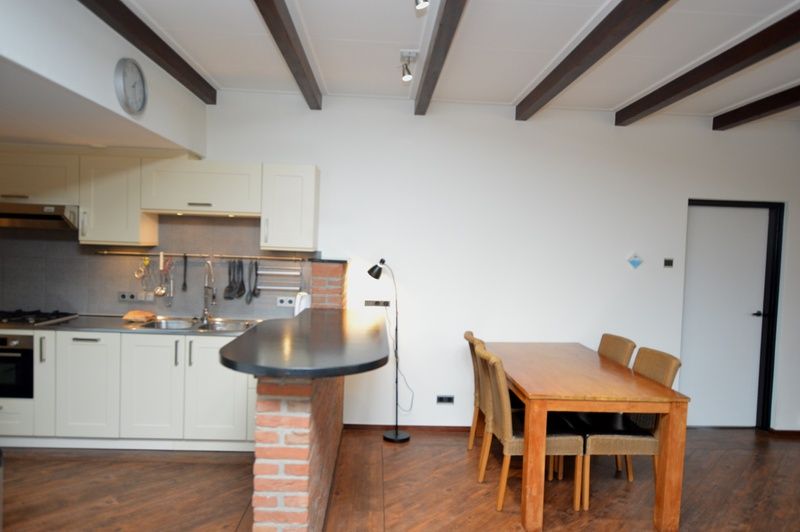 Keuken en eetkamer van Orchismient 28 in De Koog Texel met houten vloer en bar.