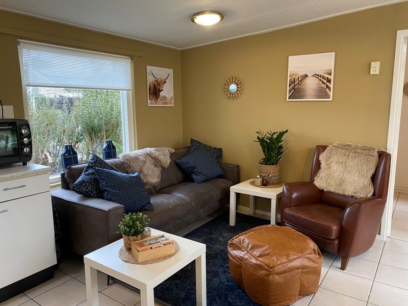 Gemuetliche Sitzecke im Bungalow 51, Bungalowpark 't Luwe Land, De Koog, Texel, mit Ledersessel.