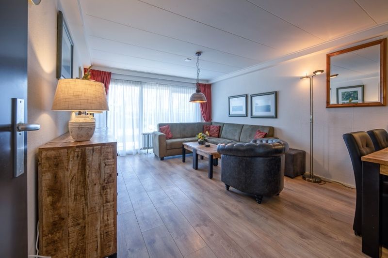 Ruime zithoek in Appartementen Anna - de Zeehond, De Koog, Texel met veel natuurlijk licht en moderne inrichting.
