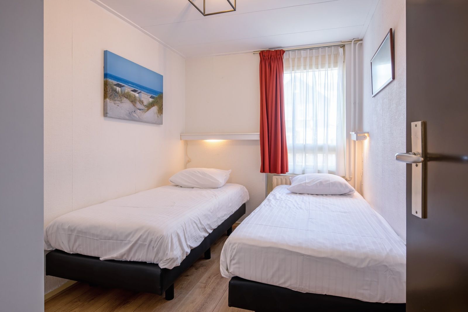 Lichte slaapkamer in Appartementen Anna - de Zeehond, De Koog, Texel met serene inrichting en natuurlijk licht.