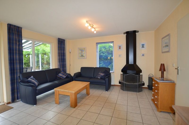 Gezellige woonkamer van Vakantiehuis Stappeland 111 in De Koog, Texel met comfortabele zithoek en open haard.