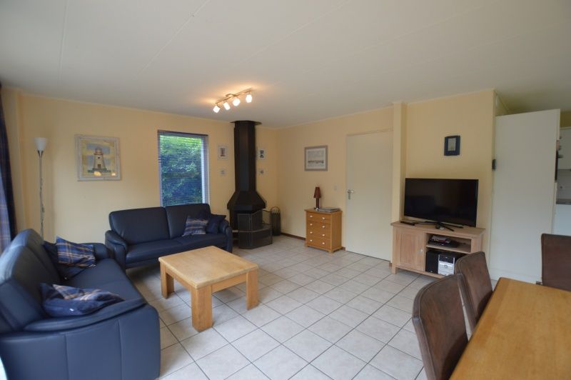 Lichte leefruimte in Vakantiehuis Stappeland 111, De Koog, Texel met moderne inrichting en uitzicht op de tuin.