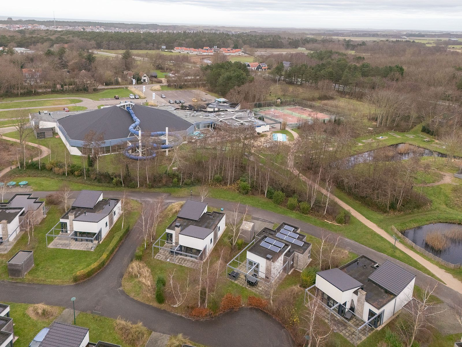 Luftaufnahme eines freistehenden Hauses in De Koog, Texel, umgeben von Natur und mit Blick auf die Watteninseln.