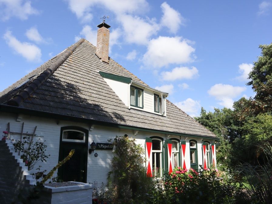 Voorhuis vakantiehuis in De Koog, Texel met charmante gevel en landelijke omgeving.