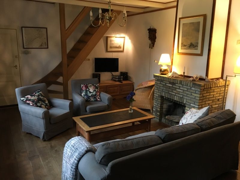 Knusse woonkamer van Voorhuis vakantiehuis in De Koog, Texel met open haard en comfortabele zitplaatsen.