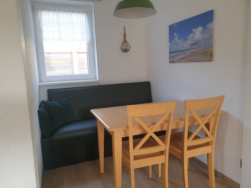 Essecke von De Duinpan - Duinhuisje Texel in De Koog, Texel, mit Holztisch und bequemem Sofa.