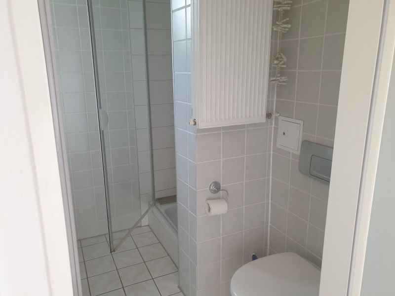 Gepflegtes Badezimmer von De Duinpan - Duinhuisje Texel in De Koog, Texel, mit Dusche und Toilette.