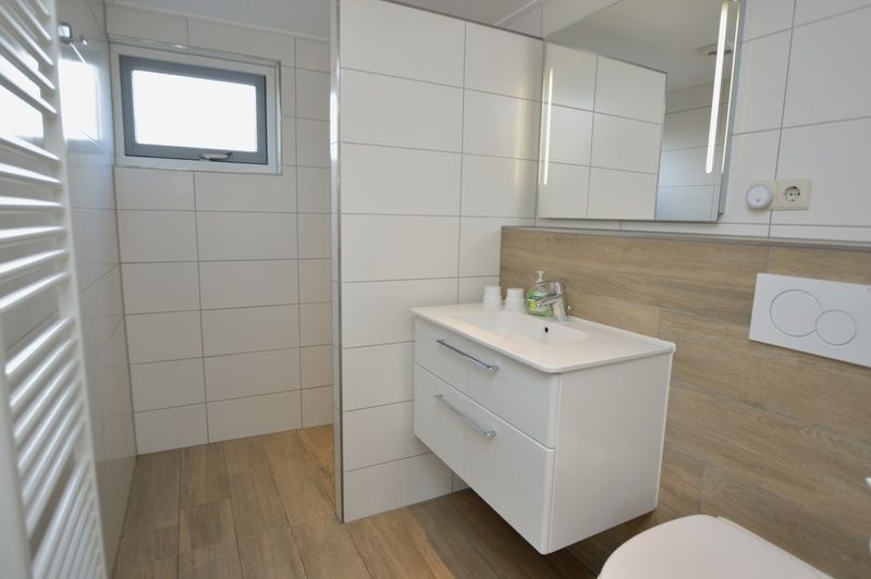 Frisches Badezimmer im Ferienhaus Stappeland 215, De Koog, Texel, mit modernen Annehmlichkeiten und geraeumiger Dusche.