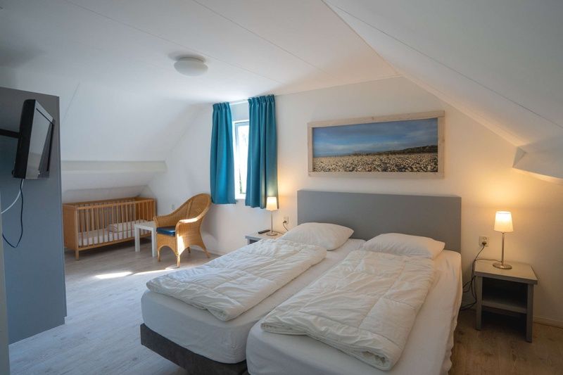 Gemuetliches Schlafzimmer im Ferienhaus Stappeland 215, De Koog, Texel, mit extra Platz fuer ein Kinderbett, ideal fuer Familien.