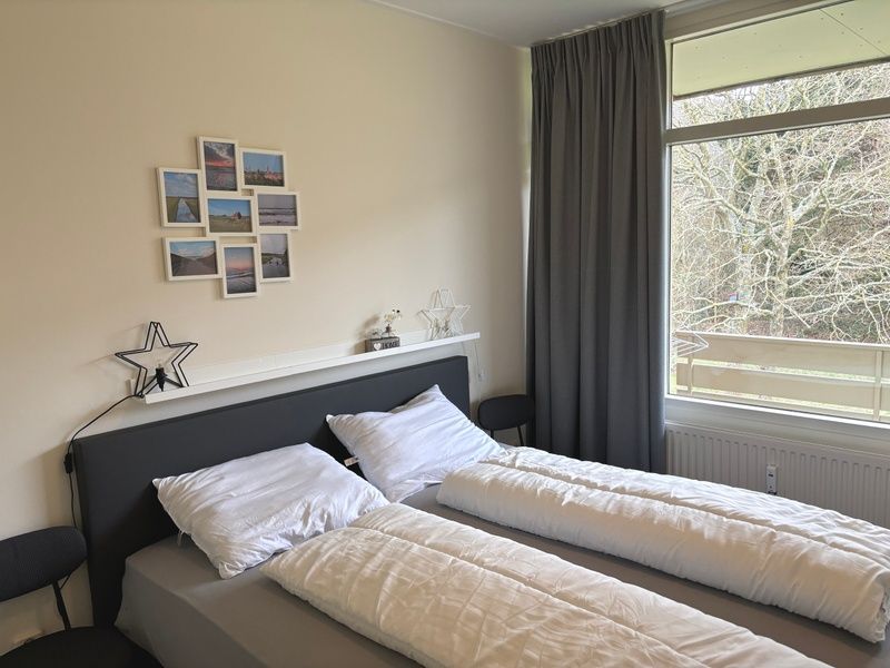 Gemuetliches Schlafzimmer im Apartment Kerckeland 40, De Koog, Texel mit grossem Fenster und Aussicht.